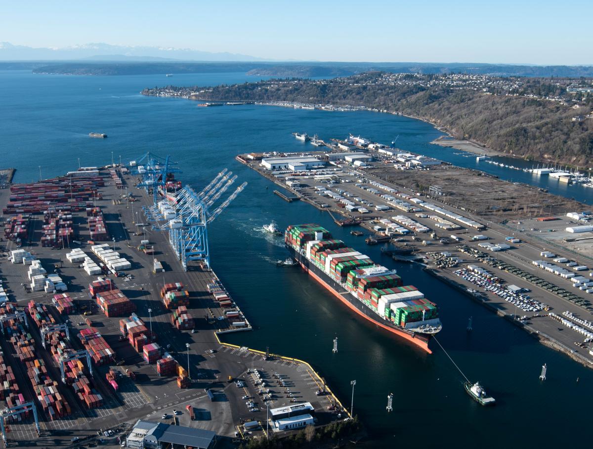 aerial photo of a seaport with a vessel navigating in the waterway